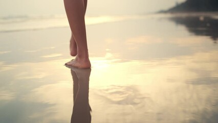 B roll - Woman feet walking along sea water waves on sandy beach in sunset, Female tourist on summer travel vacation, Slow motion