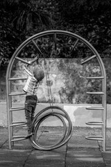 series shots of a poor boy who was having fun and playing with cycle tyre in the park