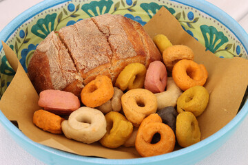 Various flavors of Apulian taralli and a sandwich in a basket on a restaurant table