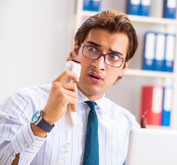 Businessman disgusted with cockroaches in the office