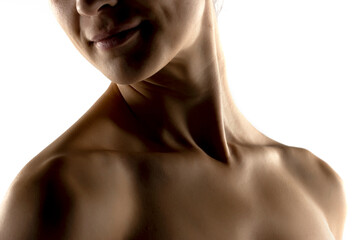 The close-up of a young woman's neck in the shadow on white background
