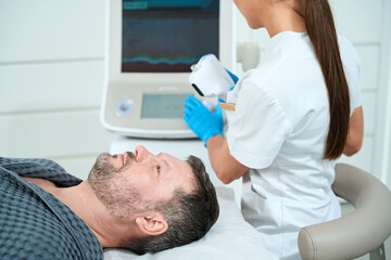 Male with unshaven lies on a cosmetology couch