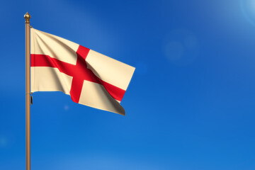 England. Flag blown by the wind with blue sky in the background.