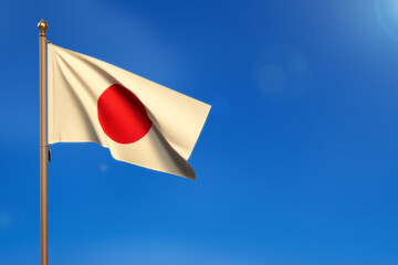 Japan. Flag blown by the wind with blue sky in the background.