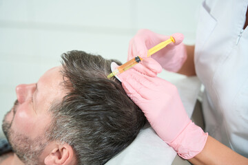 Middle-aged patient is placed on a cosmetology chair