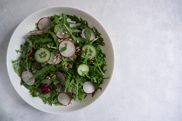 Vegetable salad with radish, cucumber and arugula. Vegetarian snack with fresh vegetables. Healthy, dietary snack, snack.