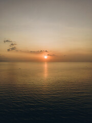 The sun sets over a peaceful body of water, painting the sky in beautiful colors sunset background