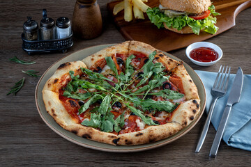 Home made pizza topped with black forest ham, tomatoes, spices, black olives.