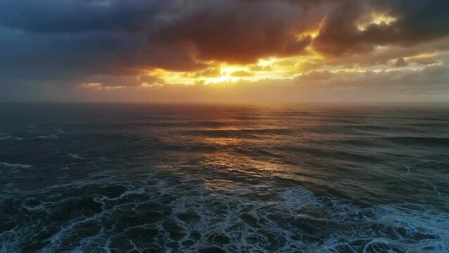 Aerial view on big waves of Atlantic ocean and dramatic sunset sky, 4k