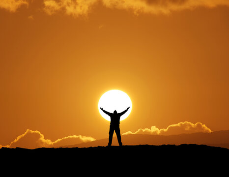 Silhouette of man and big sun.