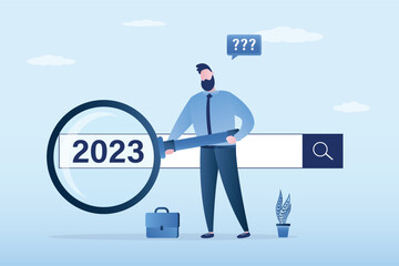 2023 job research or vision. New Year resolution. New business opportunities or career challenges. Businessman uses magnifying glass for discovering websites from search box.