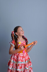 menina sorridente c&ocirc;mica com roupa colorida de festa junina 