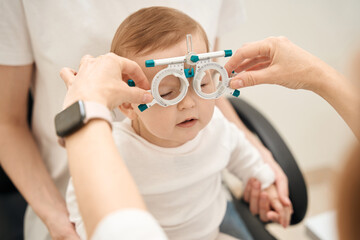 Pediatric optometrist preparing baby for visual acuity test