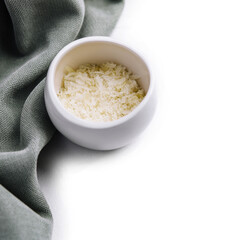 Grated aged italian parmesan cheese in white bowl
