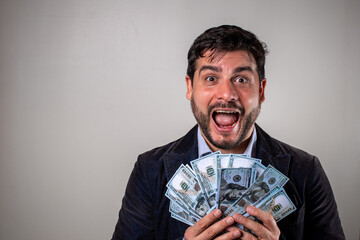 Hombre eufórico sosteniendo mucho dinero