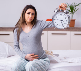 Young pregnant woman in the bedroom
