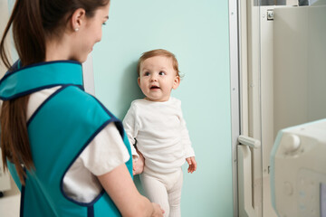 Woman supporting her baby during radiographic procedure