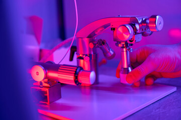 Male hand maintaining and adjusting joystick of micromanipulator