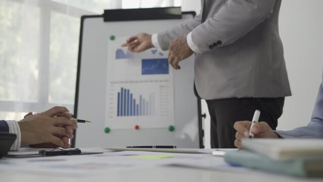 Accountant pointing to business graph chart Financial business report in chart Closeup brainstorming on a project with his partners working together to plan a success strategy