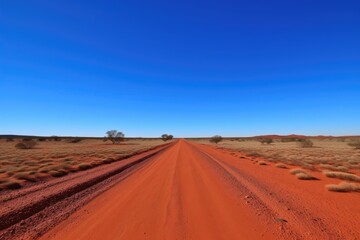 Fototapeta na wymiar remote desert road, with red sand and blue sky in the background, created with generative ai