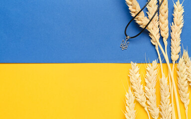 Pendant with coat of arms of Ukraine and wheat spikelets against Ukrainian flag