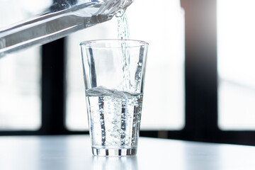 woman pouring mineral water to glass.