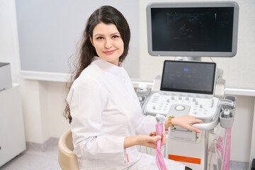 Young doctor sitting near equipment in the hospital