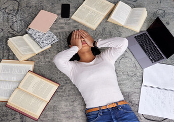 Study anxiety, fatigue and woman student on ground with textbook for test feeling overworked. Stress, female person and home studying for university exam and course with laptop for elearning online