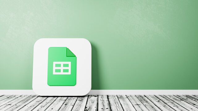 Google Sheets App Icon on Wooden Floor Against Wall