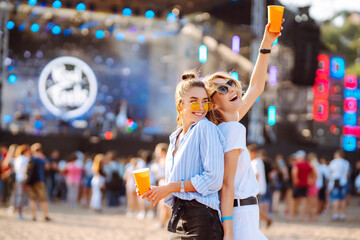 Happy girlfriends having fun at music festival. Summer holiday, vacation concept. Friendship and...