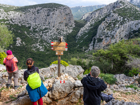 Wanderurlaub einer Gruppe auf Sardinien, Italien: Wandern im Osten der Insel bei der berühmten historischen Stätte Tiscali - Wegweiser, Schilder