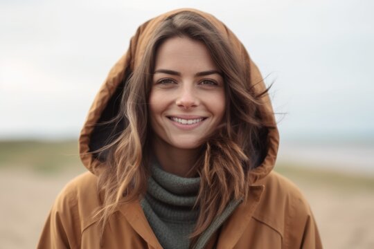 Portrait of a beautiful young woman in a coat on the beach