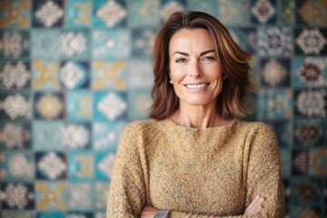 Fototapeta premium Portrait of a beautiful mature woman standing in front of a mosaic wall