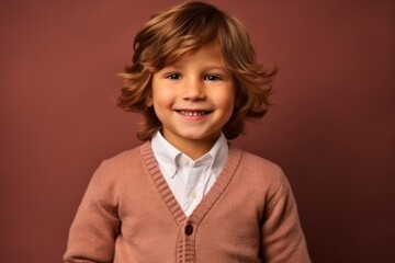 Portrait of a cute little boy in a brown sweater on a brown background