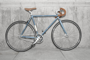 Vintage fixed gear bicycle near concrete wall in the city