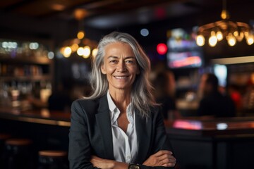 Portrait of senior businesswoman in a bar, looking at camera.