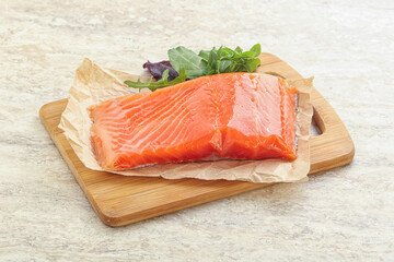 Raw salmon fillet over board