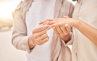 Couple, hands and engagement in closeup at beach with care, achievement or love on vacation in...