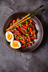 Tteokbokki, Teopokki fried rice cake in black bowl.