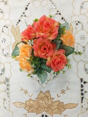 Fototapeta na wymiar colourful plastic flowers on a white tablecloth