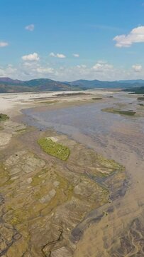 Aerial drone of shallow river bed in a mountain valley. Bucao river. Luzon, Philippines. Vertical video.