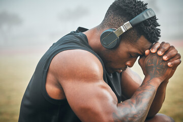 Music, training and thinking with black man in park for exercise, strong and motivation. Streaming, sports podcast and radio with male athlete and headphones for muscle, workout and challenge