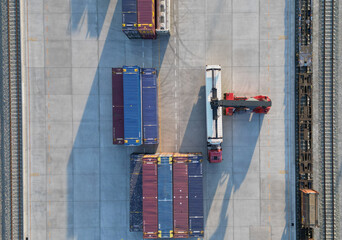Aerial top down view crane loading container from container truck to container train, Cargo train...