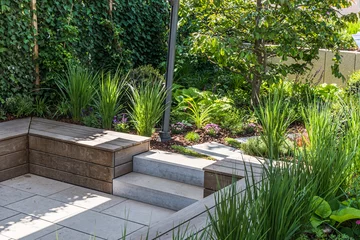 Foto op Plexiglas Cozy shady seating area made of concrete and wood in a garden © Daniela Baumann