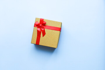 Flat lay gift with a red bow on a blue background. a Christmas gift