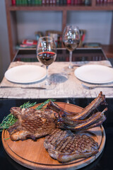 Grilled ribeye beef steak with red wine, herbs and spices on black table