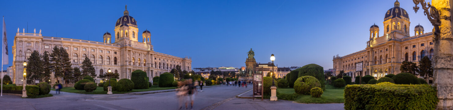Vienna museum area around Maria-Theresia square with the Museum of Art History, Museum Quarter in the background and the Museum of Natural History to the right. Twilight - visitors motion blurred.
