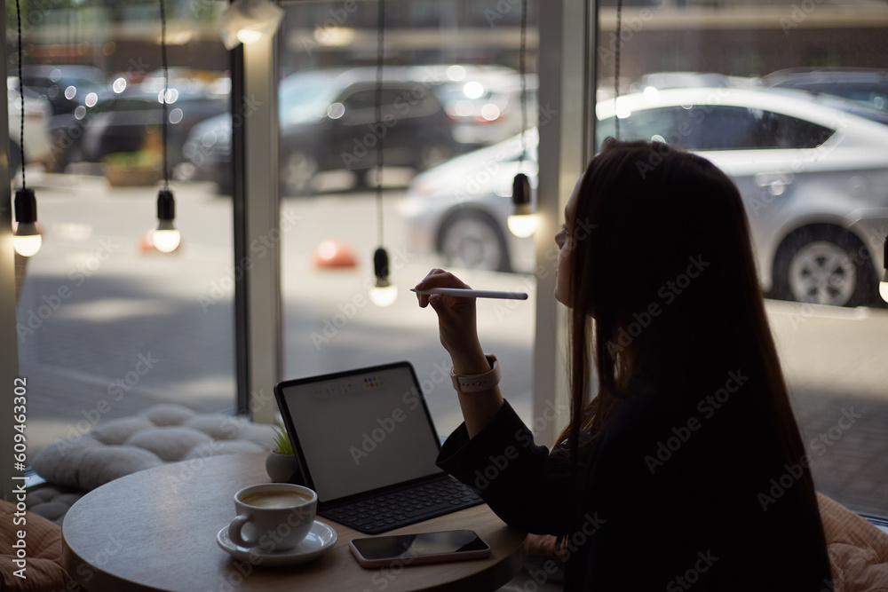 Fototapete graphic designer working in a cafe. young creative female person creating a sketch with a stylus pen