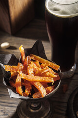 Dry chicken jerky snacks with beer in dark tones