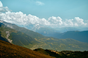 Fototapeta na wymiar Mountain ranges on a sunny day at Georgia. Sky with clouds adn hills